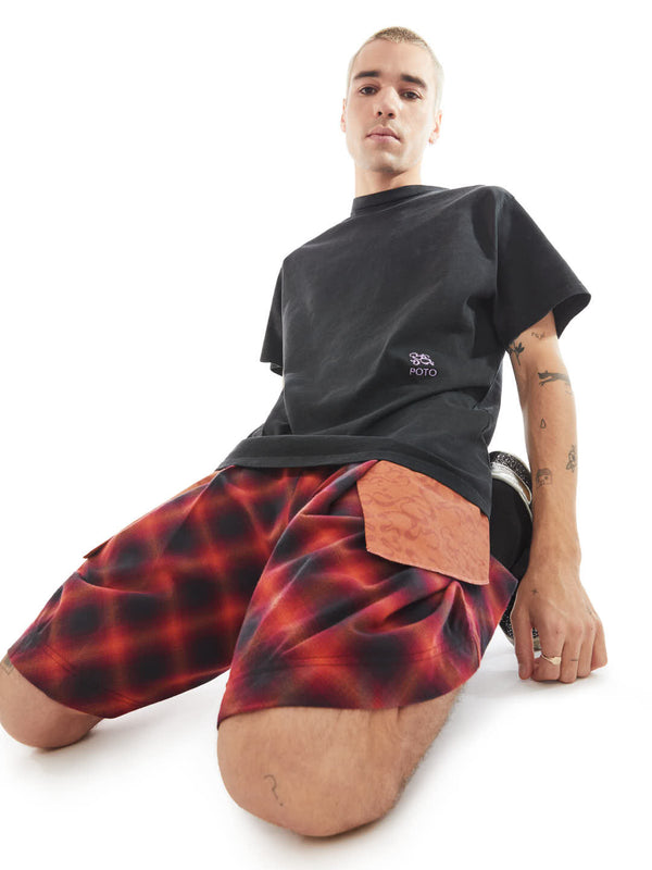 model on his knees using black t-shirt and shorts