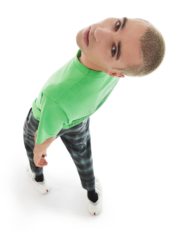 model on a relaxed pose featuring  the back of green t-shirt with fingerprint print